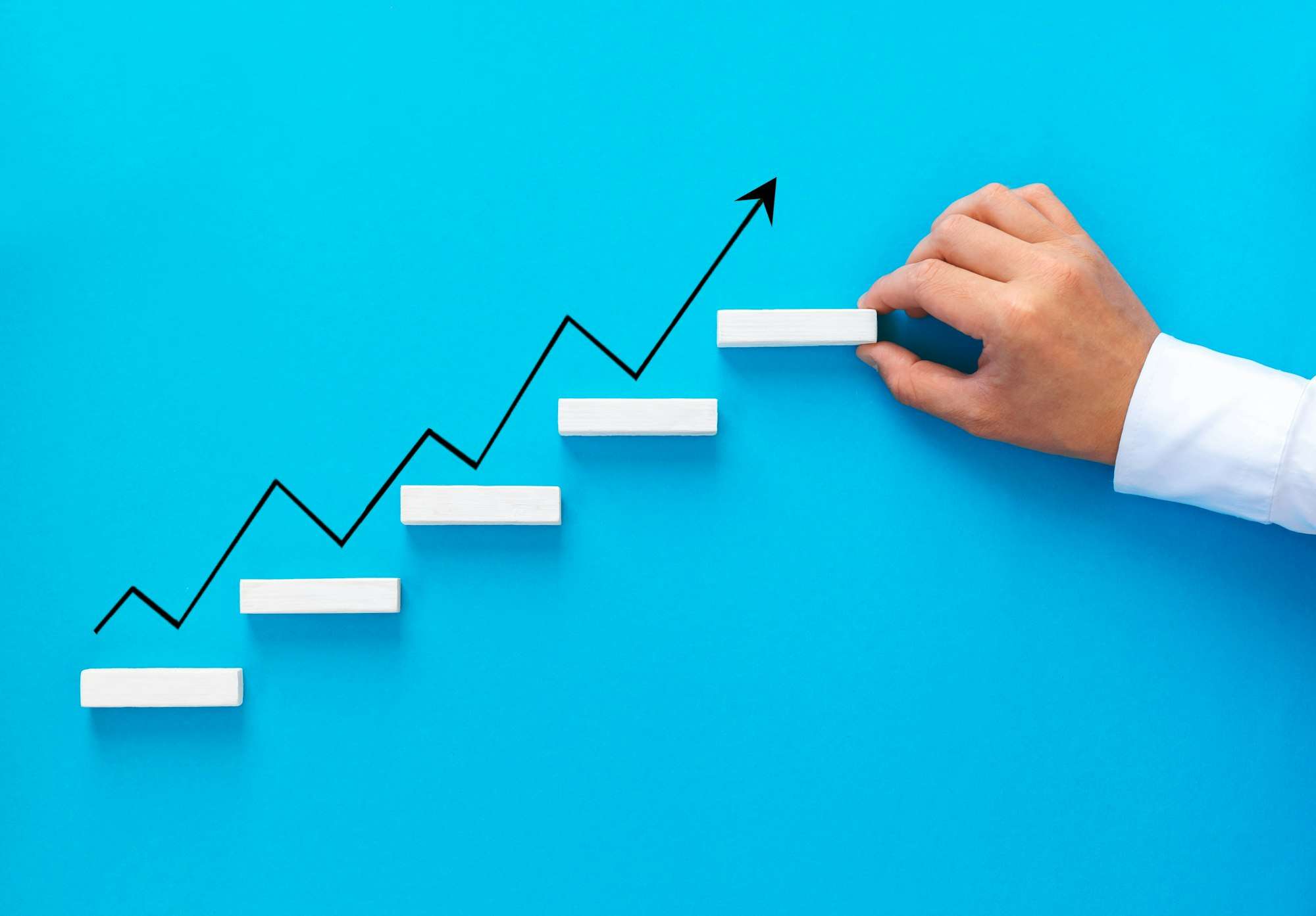 Businessman hand arranging wood block stacking as step stair with growth arrow. Business growth suc Businessman hand arranging wood block stacking as step stair with growth arrow. Business growth suc